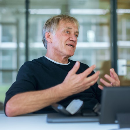 Norbert Oberhaus sitzt hinter einem Laptop und gestikuliert mit den Armen.