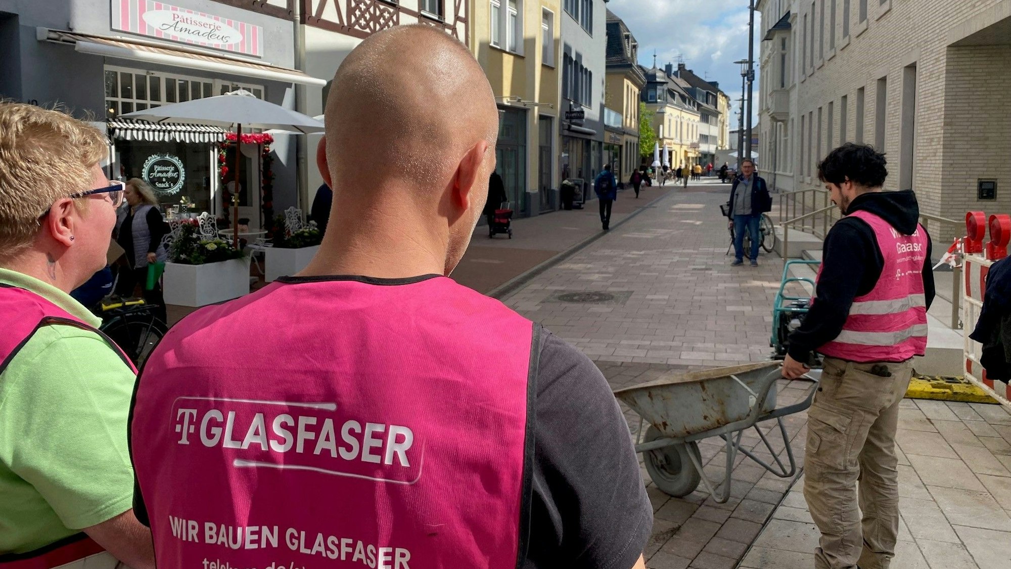 Zu sehen sind Arbeiter, die damit beschäftigt sind, in der Brühler Innenstadt Glasfaserleitungen zu verlegen.