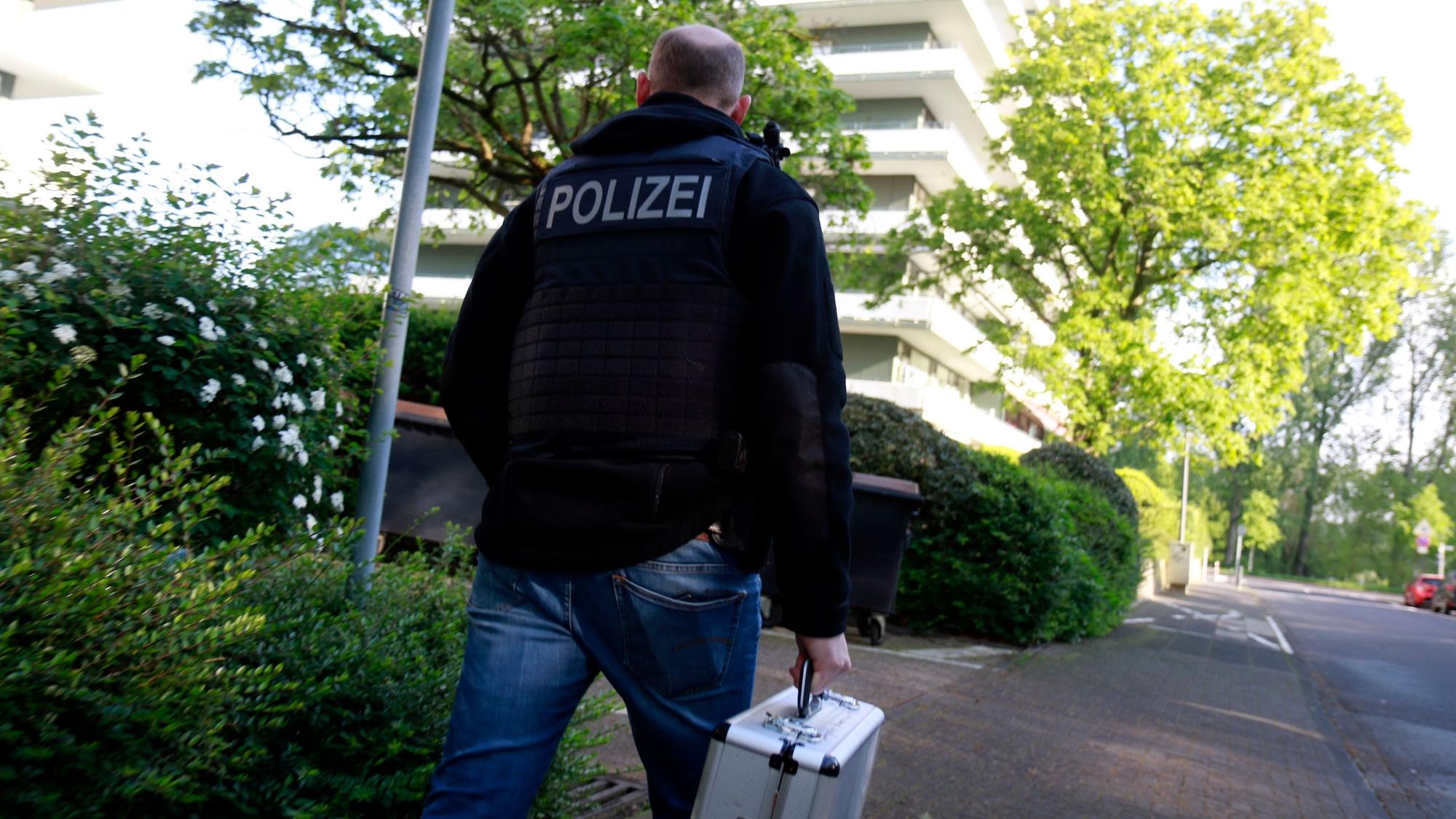 Ein Ermittler am Donnerstag (18.04.2024) auf dem Weg zu einer Durchsuchung in Rodenkirchen.