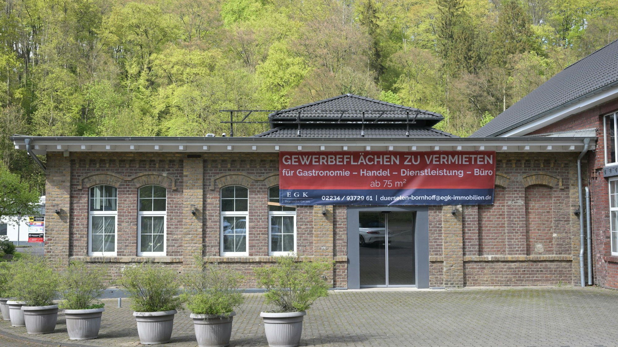 An das Gebäude aus Ziegelstein ist ein Werbebanner angebracht für potenzielle Mieter,