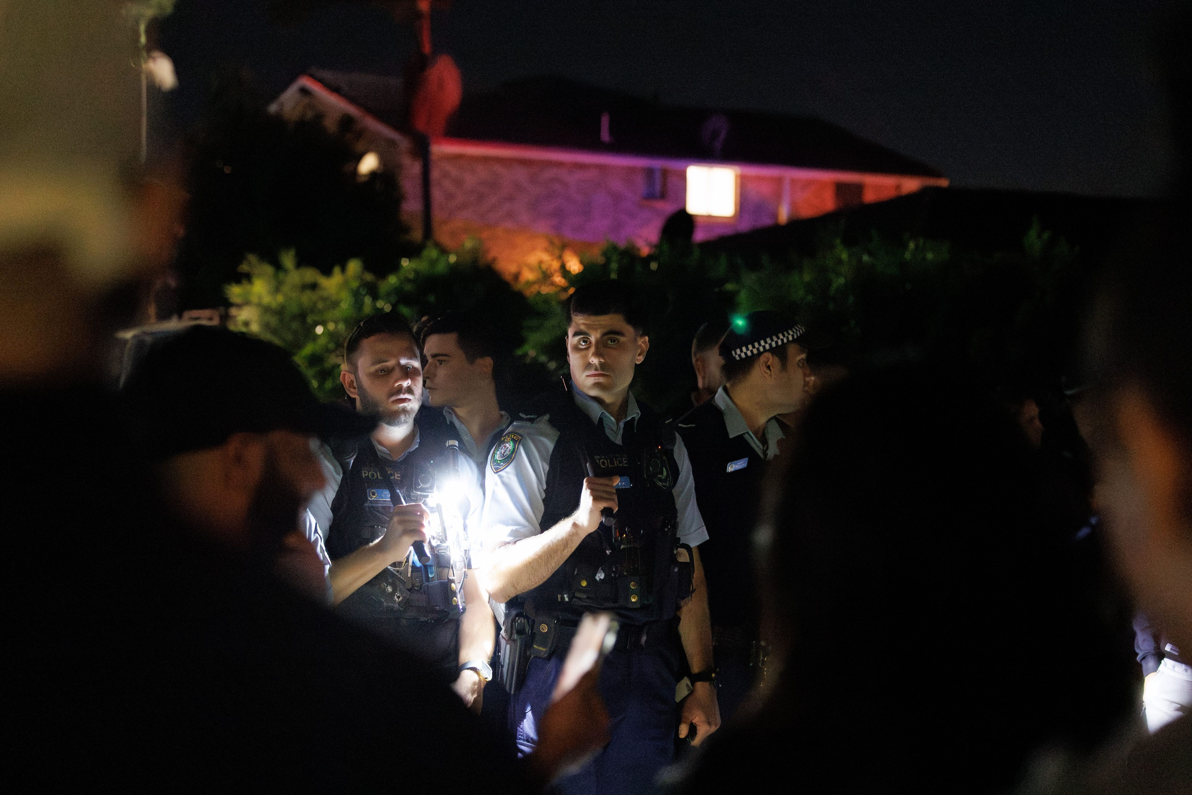 Polizisten halten Taschenlampen in der Hand.