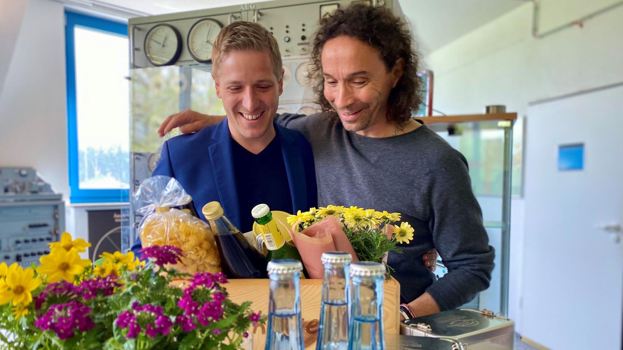Landrat Markus Ramers und Stephan Brings stehen Arm in Arm vor einer „Eifel Kiste“.