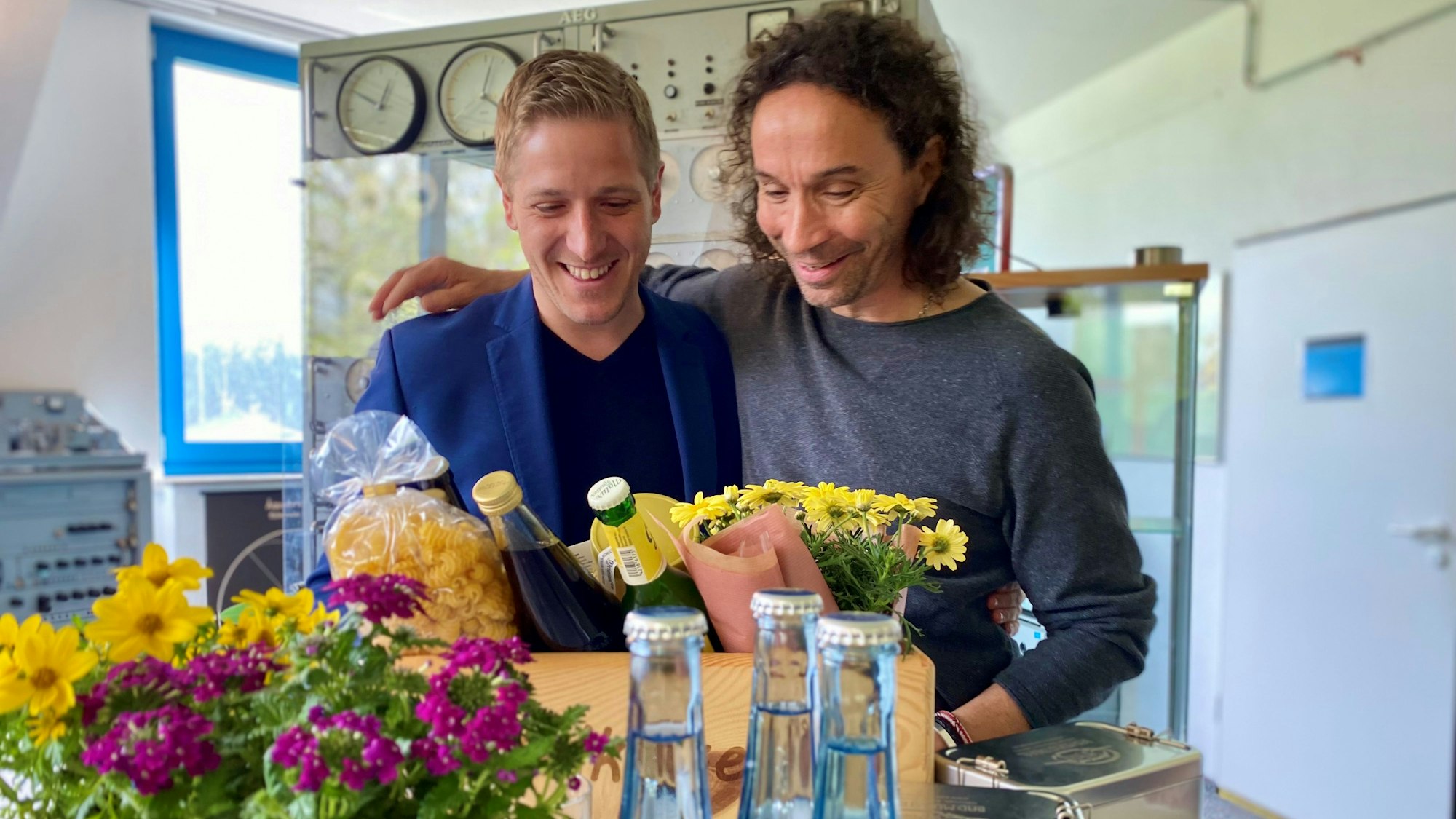 Landrat Markus Ramers und Stephan Brings stehen Arm in Arm vor einer „Eifel Kiste“.