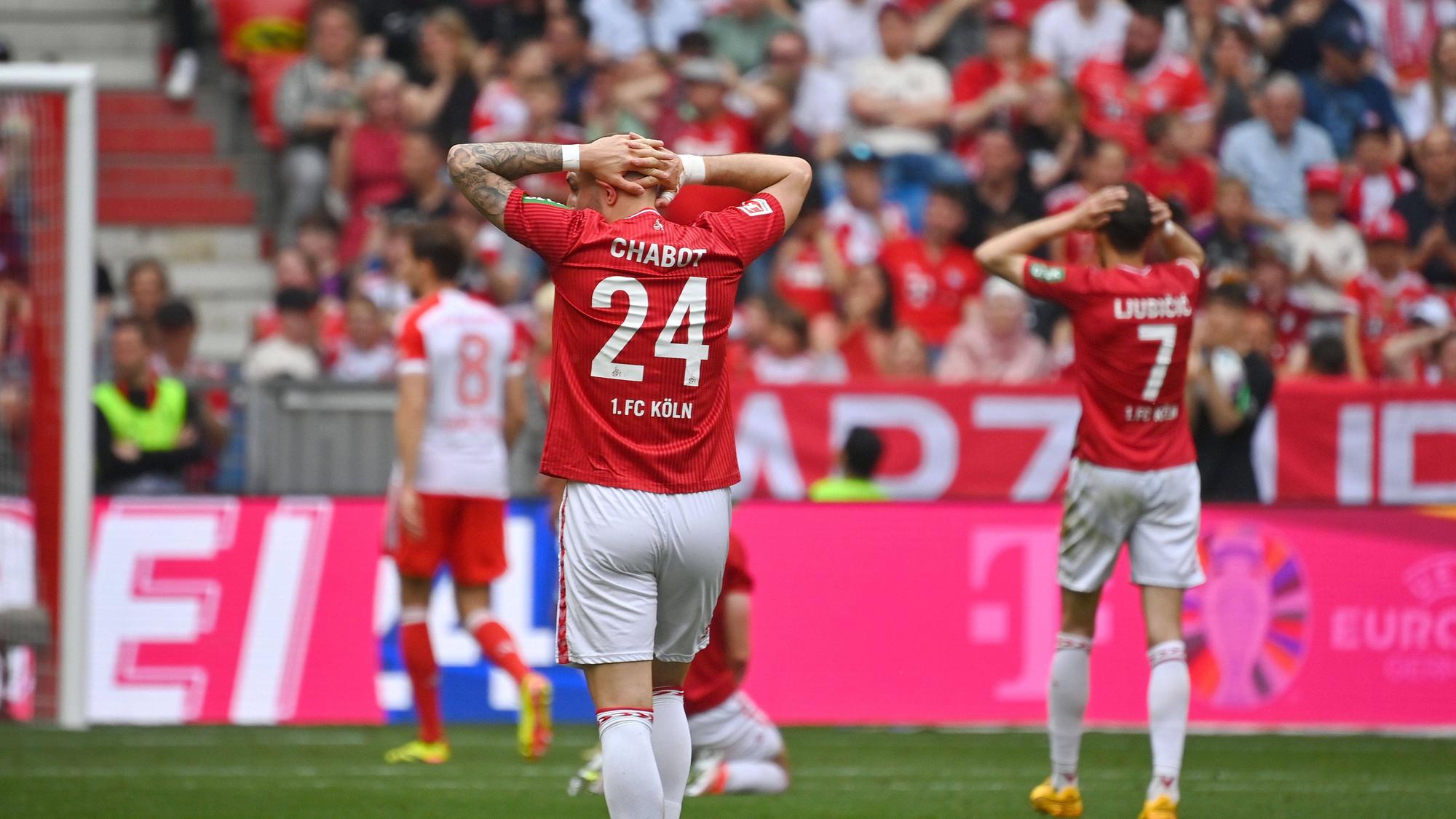 Zwei Fußballspieler verlassen frustriert und enttäuscht das Spielfeld.