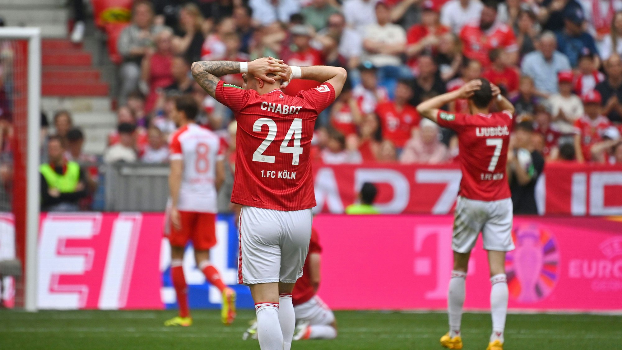 Zwei Fußballspieler verlassen frustriert und enttäuscht das Spielfeld.