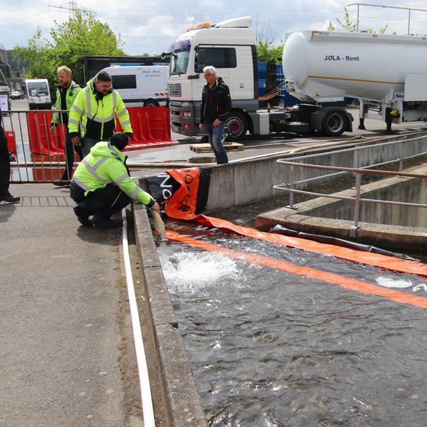 Besucher des Thementages Hochwasser/Flut schauen sich im Außengelände von Jola-Rent mobile Hochwasserschutzsysteme an.