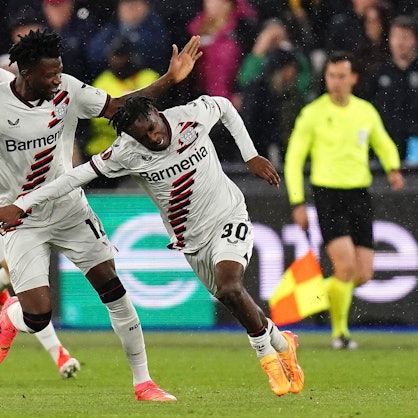 Leverkusen's Jeremie Frimpong, right, celebrates after scoring his side's opening goal during the Europa League quarterfinal second leg soccer match between West Ham and Bayer 04 Leverkusen in London, Thursday, April 18, 2024. John Walton/PA via AP)