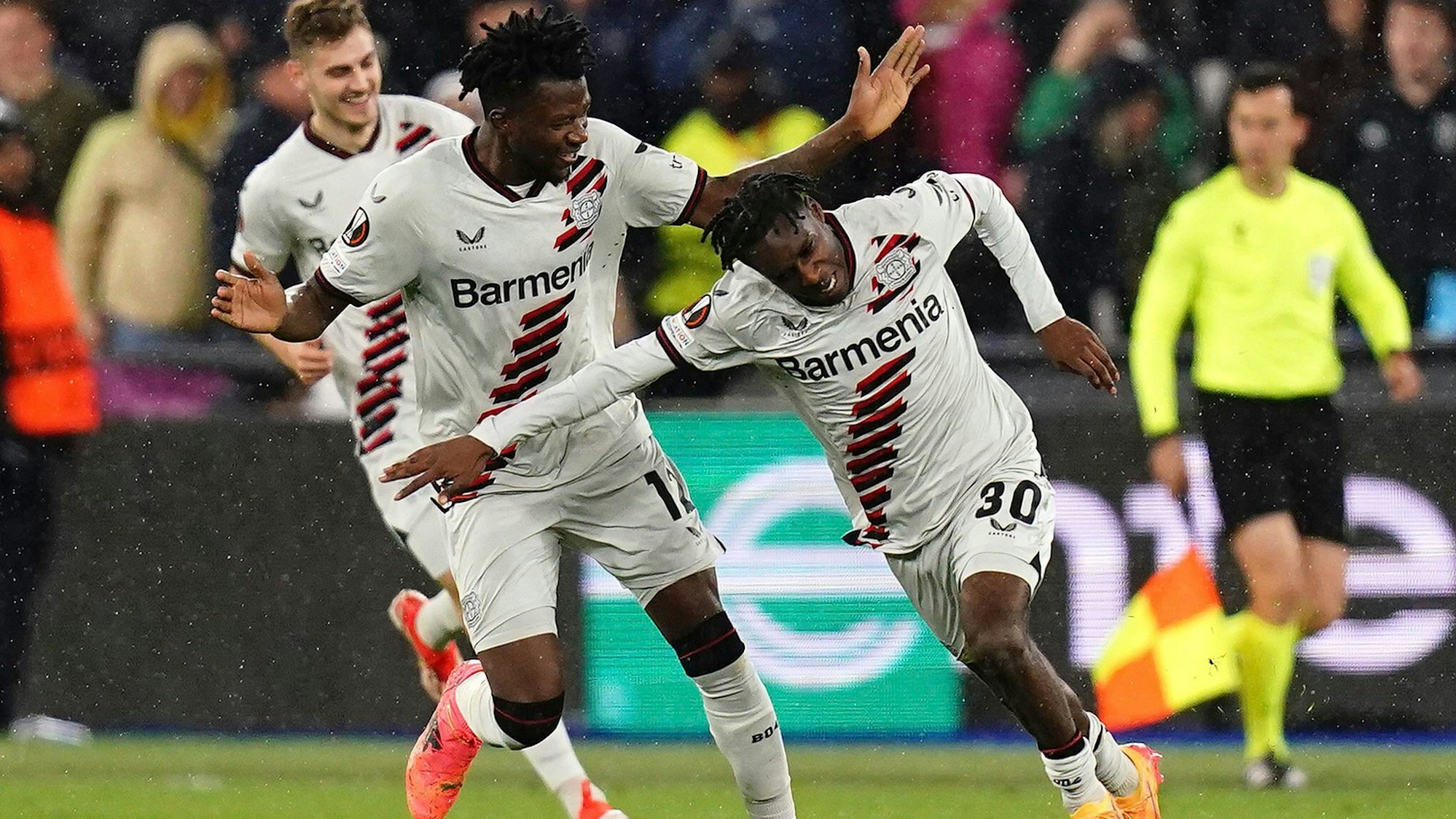 Leverkusen's Jeremie Frimpong, right, celebrates after scoring his side's opening goal during the Europa League quarterfinal second leg soccer match between West Ham and Bayer 04 Leverkusen in London, Thursday, April 18, 2024. John Walton/PA via AP)