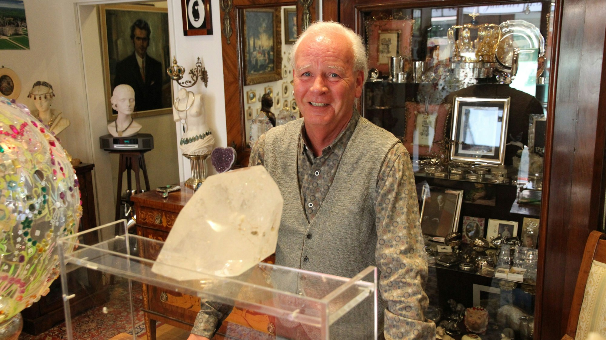 Ein Mann hinter einer Verkaufstheke mit einem großen Bergkristall