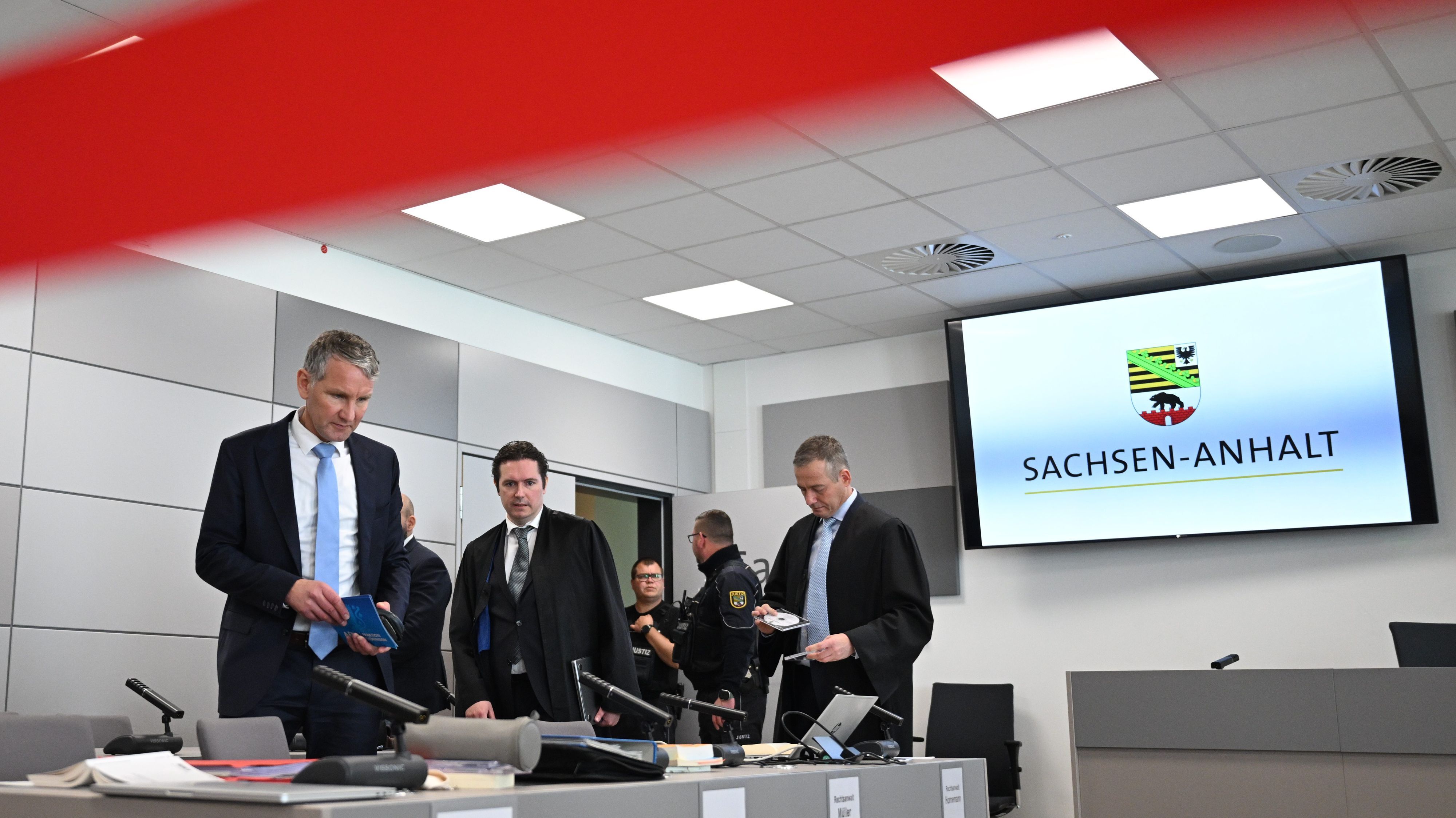 Björn Höcke (l), steht zum Ende der Pause im Gerichtssaal im Landgericht Halle.
