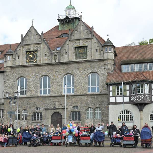 Mütter stehen mit Kinderwagen vor dem Rathaus.