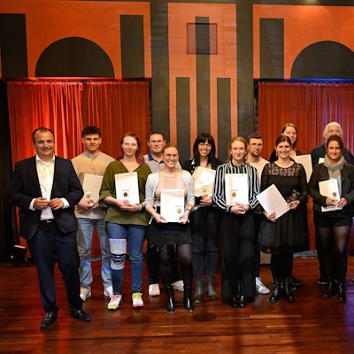 Menschen schauen mit Urkunden in die Kamera bei der Jugendbetreuerehrung im Spiegelsaal des Bergischen Löwen.