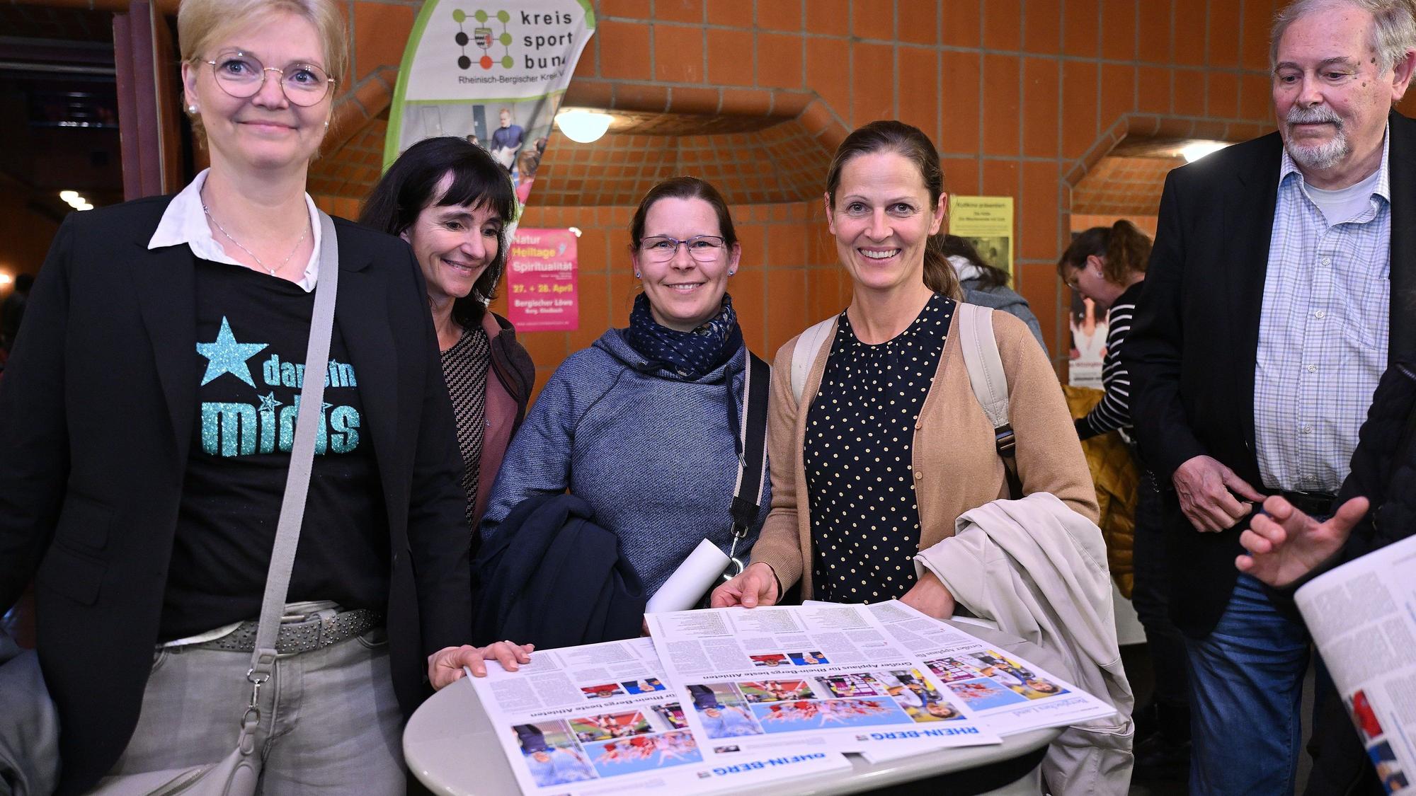Menschen lesen bei der Sportlerehrung Rhein-Berg in der Zeitung vom folgenden Tag.
