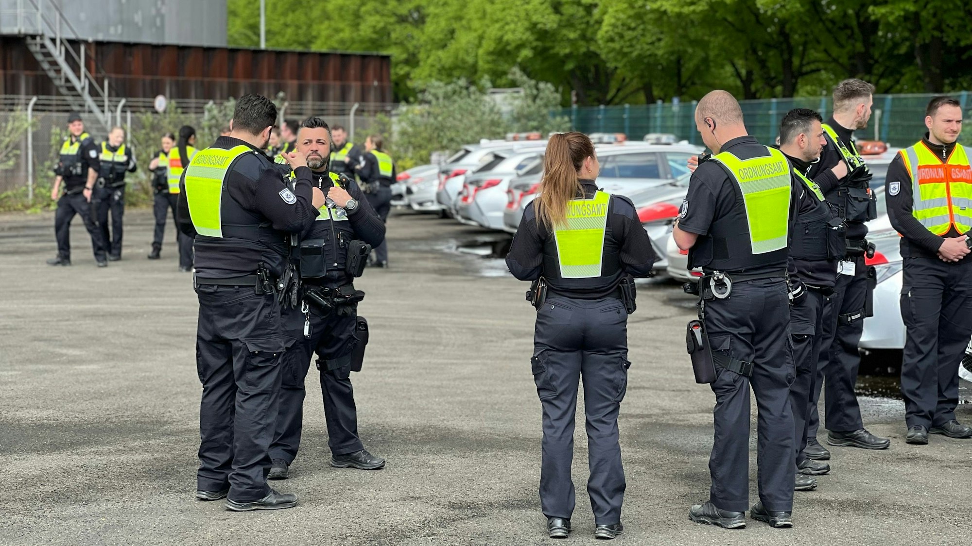 Mitarbeitende des Ordnungsamtes stehen auf einm Parkplatz.