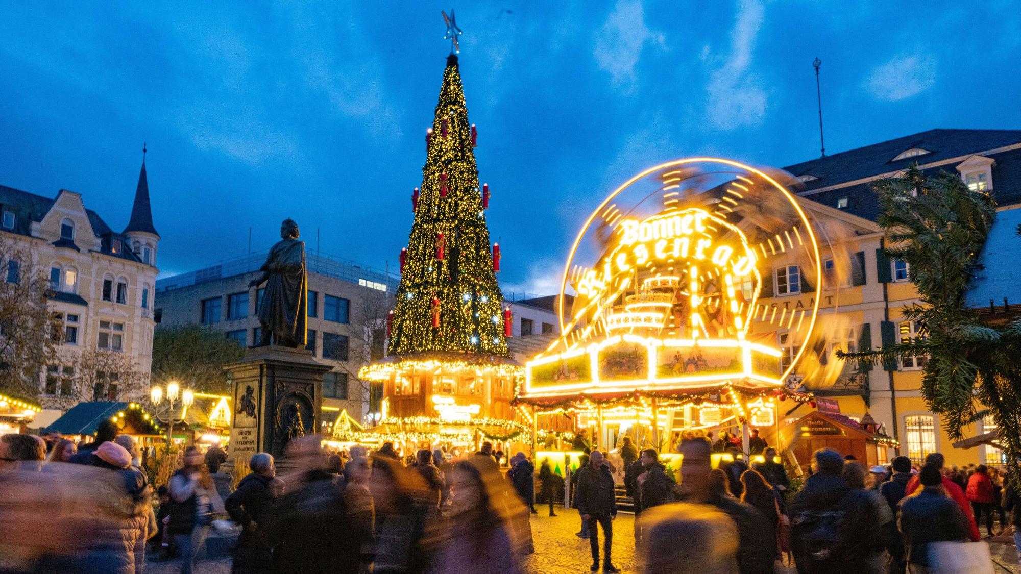 Zu sehen sind Menschen auf einem Weihnachtsmarkt.