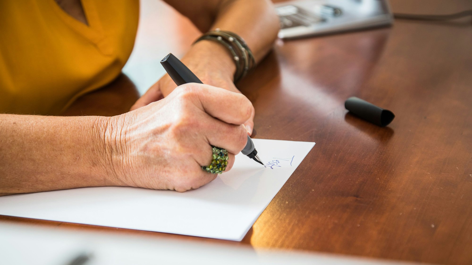 Nahaufnahme Hände einer Frau, die handschriftlich ein Testament aufsetzt. Symbolbild.