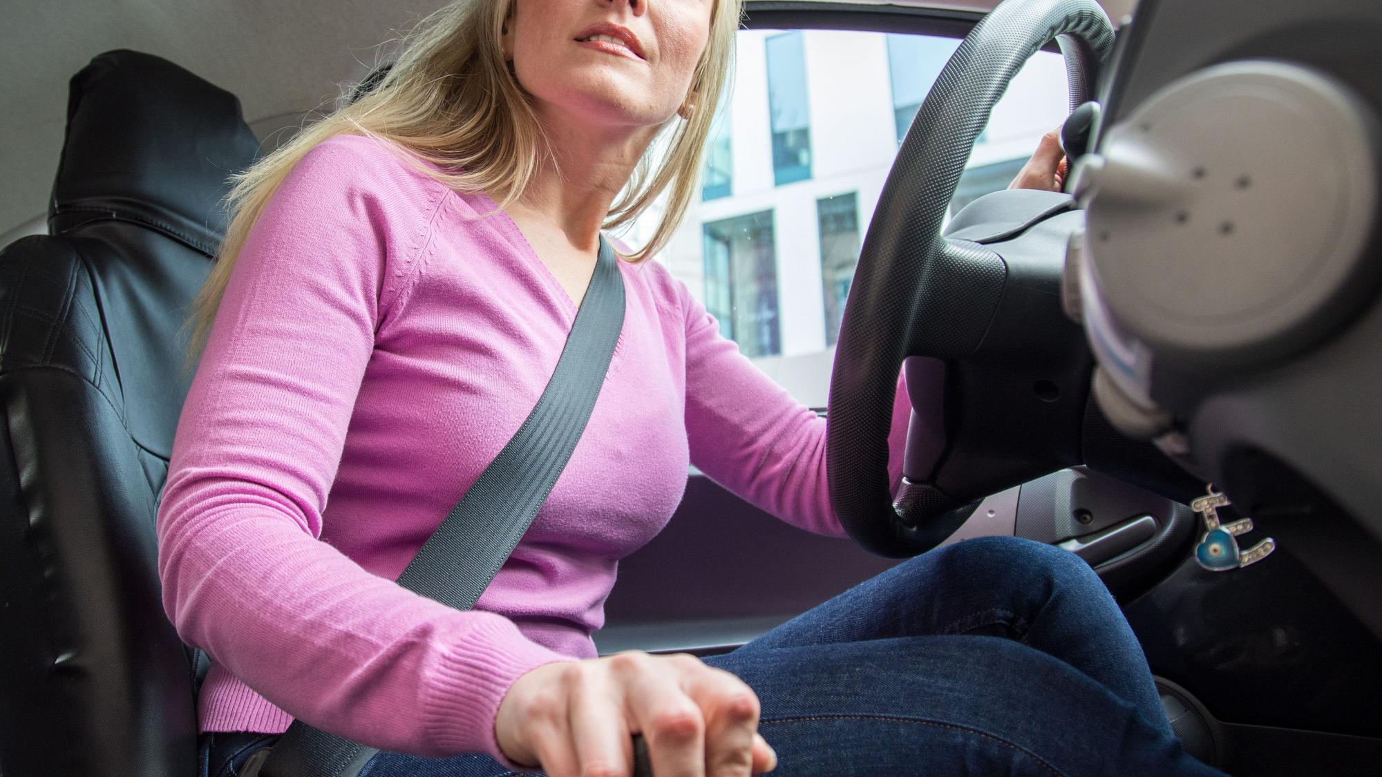 Eine Autofahrerin schaltet und schaut zur Seite