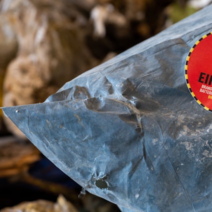 Ein Aufkleber mit der Aufschrift „Keine Akkus einwerfen“ klebt auf einem Müllsack