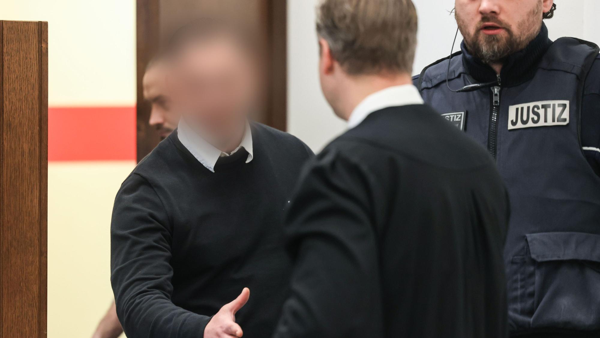 Der 28-jährige Angeklagte begrüßt seinen Verteidiger Leonhard Mühlenfeld beim Prozessauftakt im Landgericht Köln.