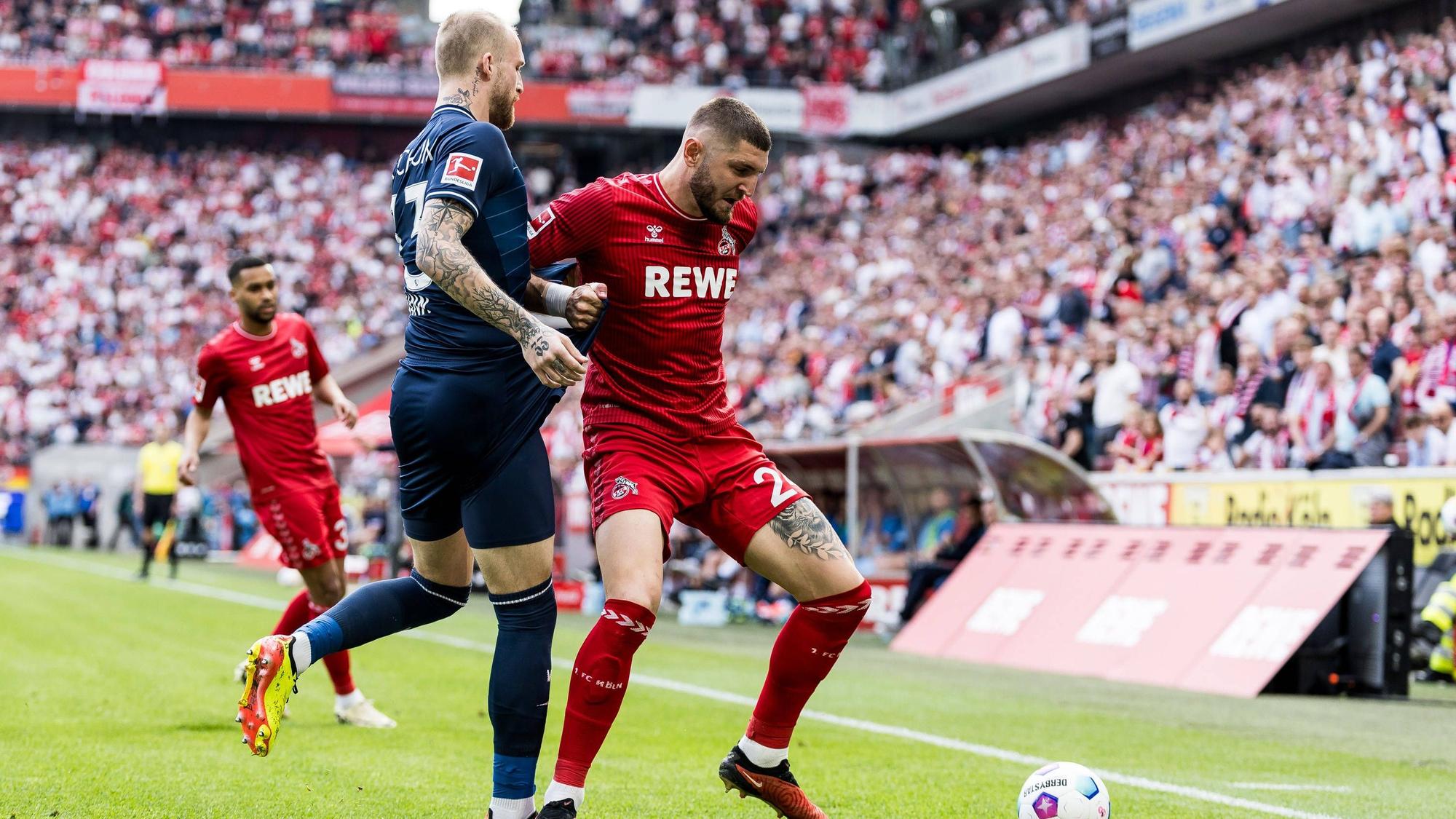 Jeff Chabot bei seiner Paradedisziplin im Zweikampf mit Bochums Philipp Hofmann. Im Hintergrund schaut Flügelspieler Linton Maina und das ausverkaufte Stadion zu.
