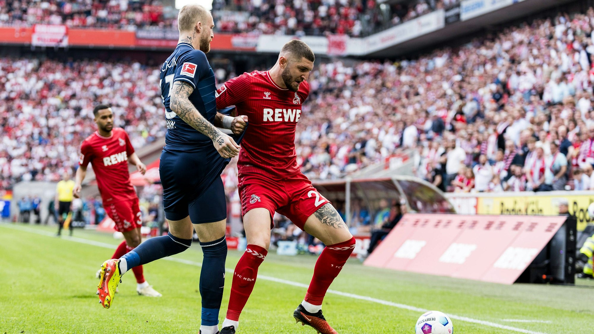 Jeff Chabot bei seiner Paradedisziplin im Zweikampf mit Bochums Philipp Hofmann. Im Hintergrund schaut Flügelspieler Linton Maina und das ausverkaufte Stadion zu.