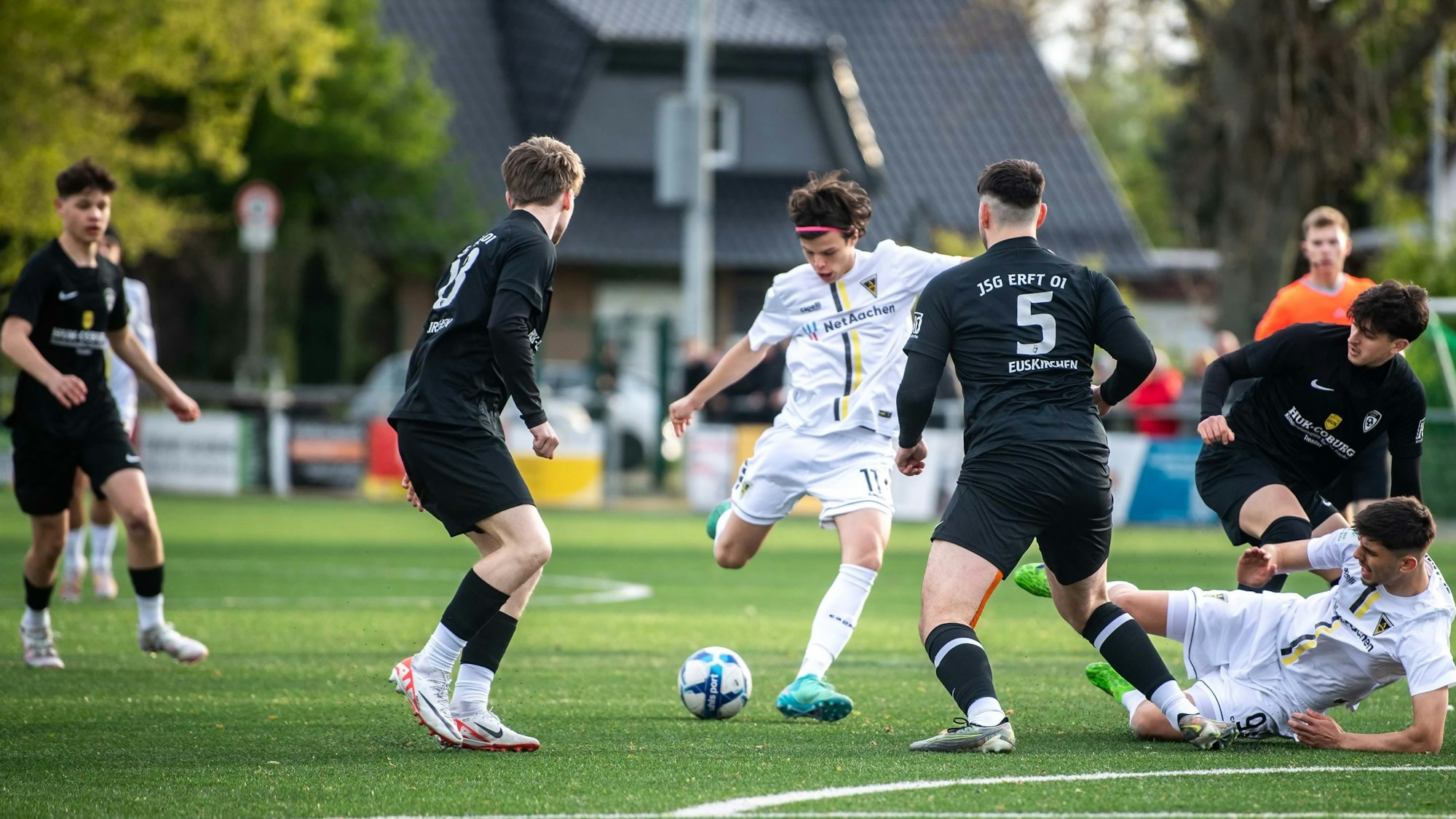 Das Bild zeigt die JSG Erft in schwarzen Trikots, wie sie mit viel Einsatz einen Torschuss versucht zu verhindern.