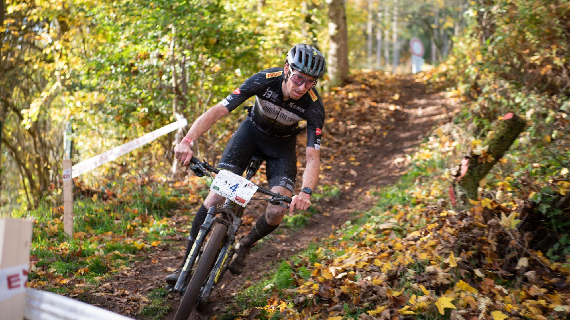 Ein Mountainbiker fährt über einen Waldweg.