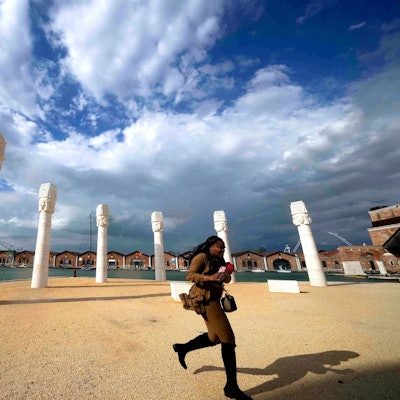 Ein Besucher läuft vor einer Reihe von Stelen vorbei, der Himmel ist bewölkt..