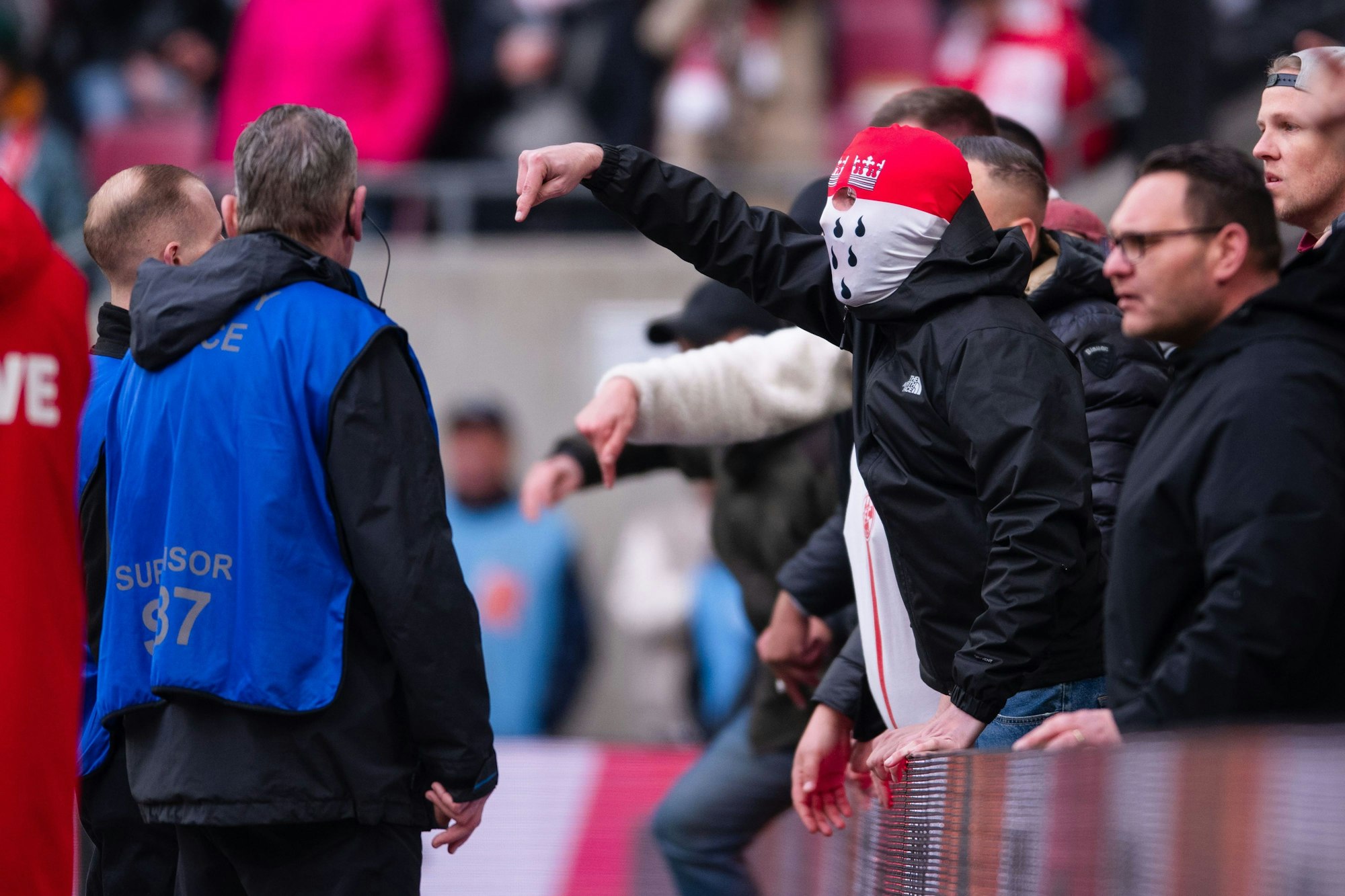 Anhänger des 1. FC Köln gestikulieren nach der Partie am Spielfeldrand in Richtung der Mannschaft und teilen ihren Ärger über die Niederlage.