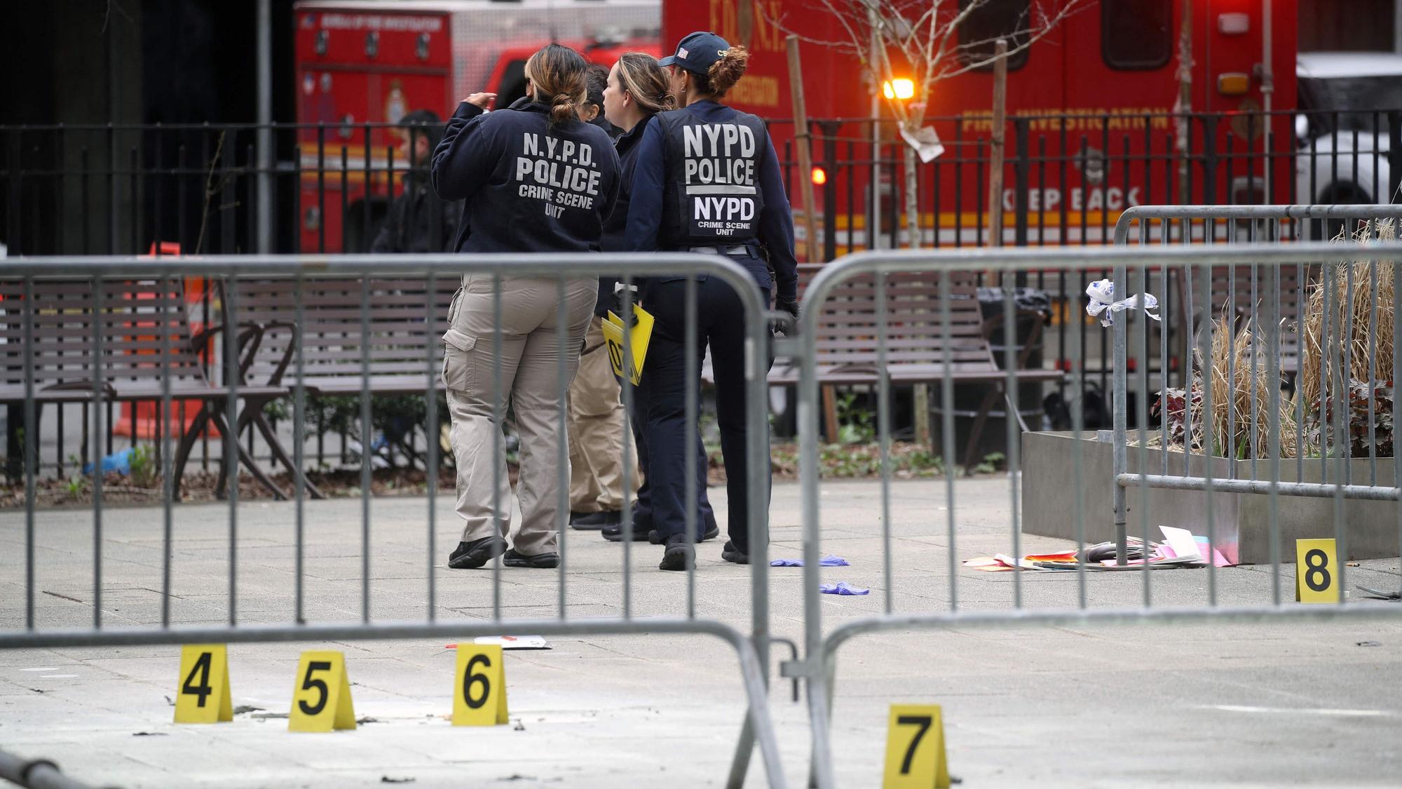 New Yorker Polizistinnen sammeln Beweisstücke nachdem sich ein Mann vor dem Gerichtsgebäude selbst angezündet hat und Flugblätter mit Verschwörungstheorien verteilt hat.