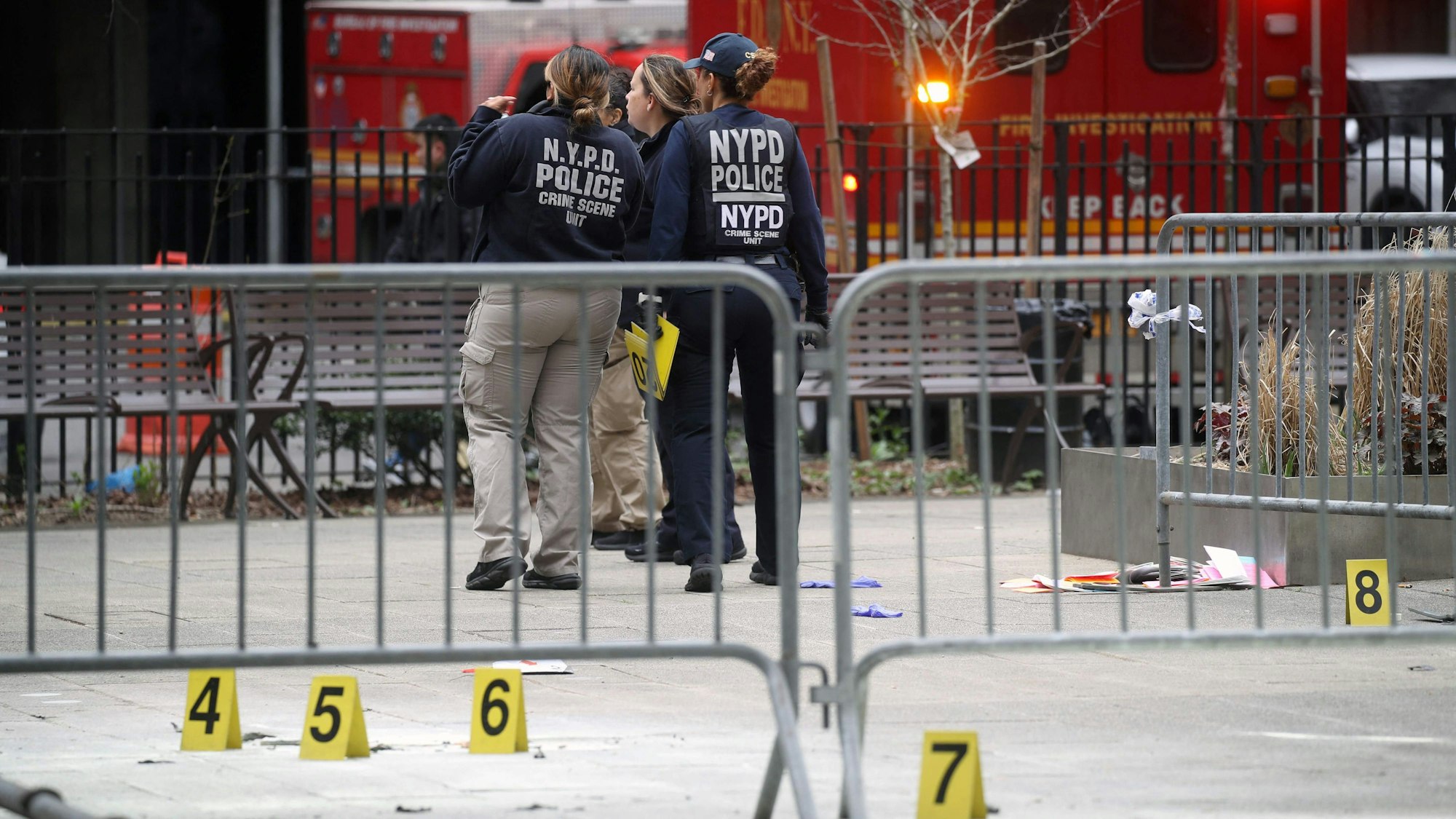 New Yorker Polizistinnen sammeln Beweisstücke nachdem sich ein Mann vor dem Gerichtsgebäude selbst angezündet hat und Flugblätter mit Verschwörungstheorien verteilt hat.