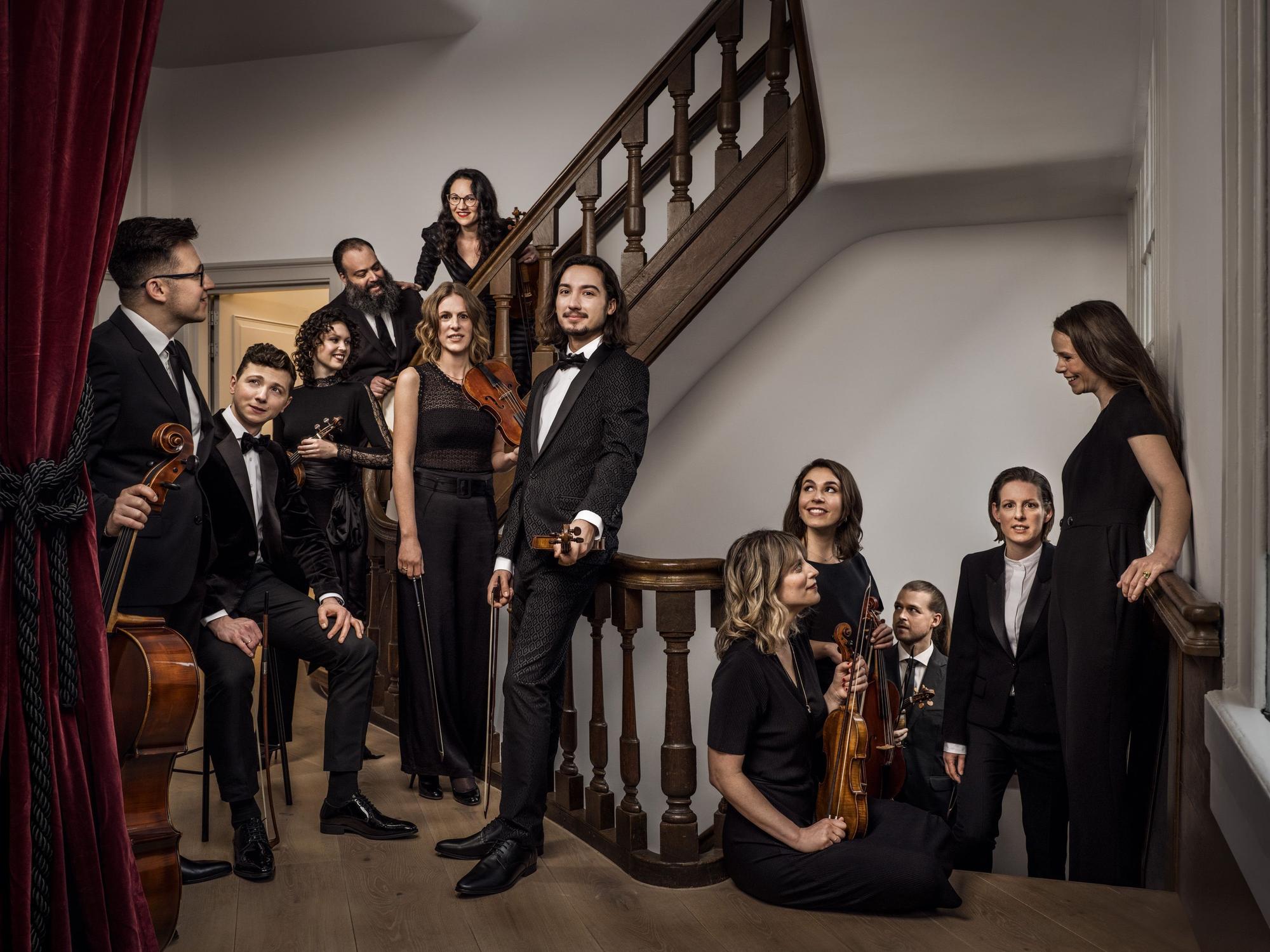 Das Ensemble von Holland Baroque posiert in einem Treppenhaus.