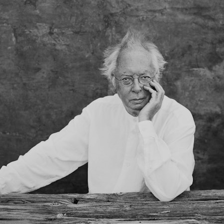 Philippe Herreweghe trägt ein weißes Hemd und schaut ernst in die Kamera.