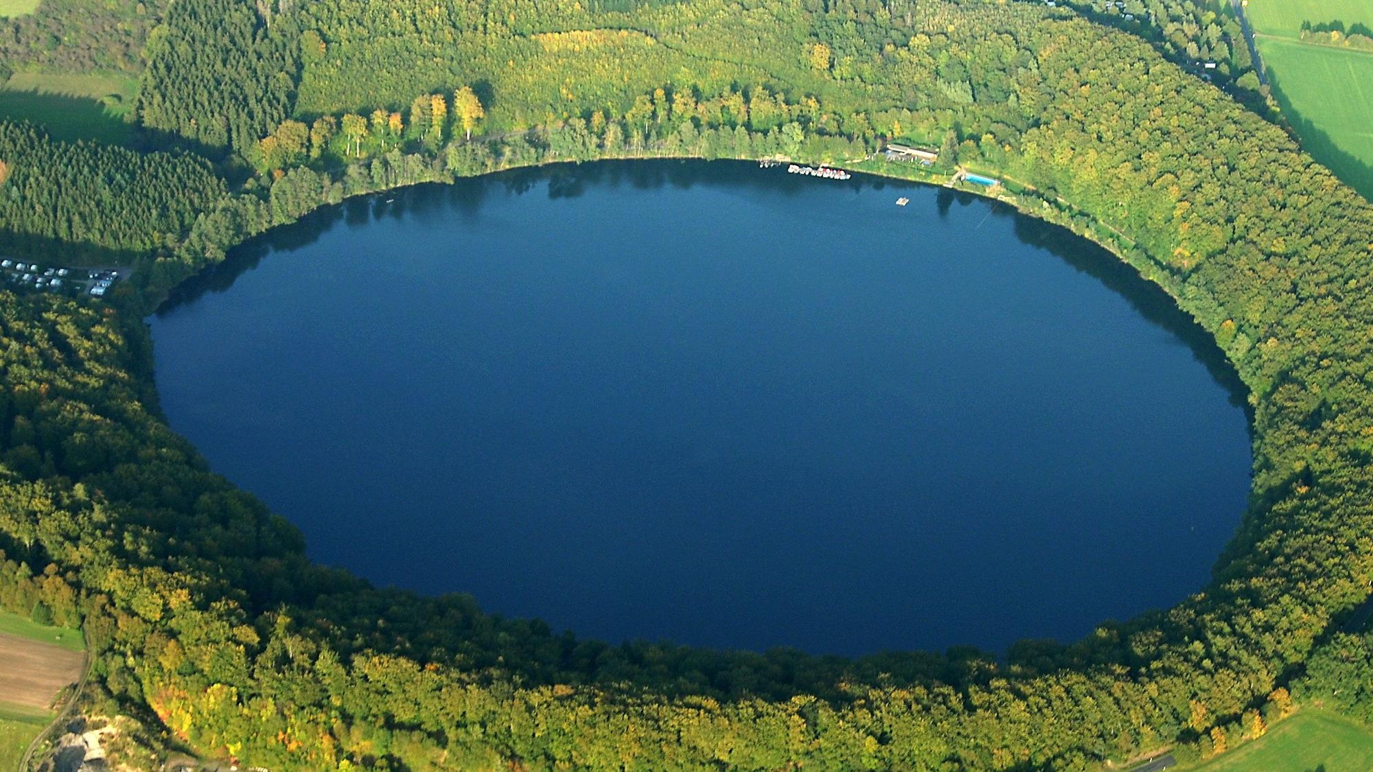 Eine Luftaufnahme zeigt das durch einen gewaltigen Vulkanausbruch entstandene Pulvermaar in der Eifel. Forscher haben 60 Kilometer entfernt von Köln Hinweise auf einen neuen Vulkan unter dem Laacher See gefunden.