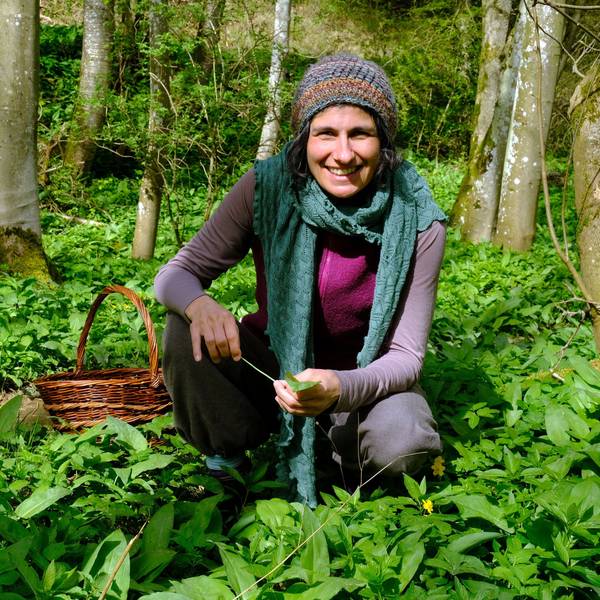 Naturpädagogin Jasmin Khalil kniet inmitten von Bärlauchpflanzen im Wald.