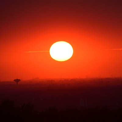 Das Foto zeigt eine glühende Sonne über Bergisch Gladbach und Köln