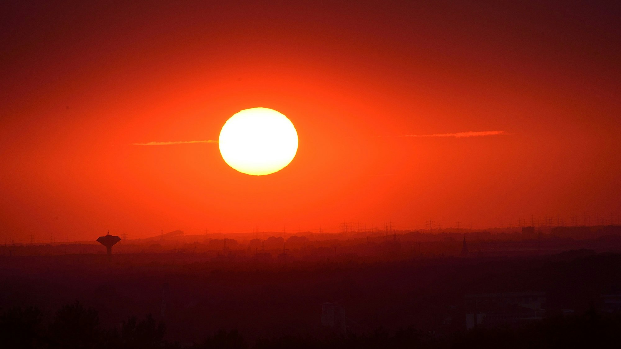 Das Foto zeigt eine glühende Sonne über Bergisch Gladbach und Köln