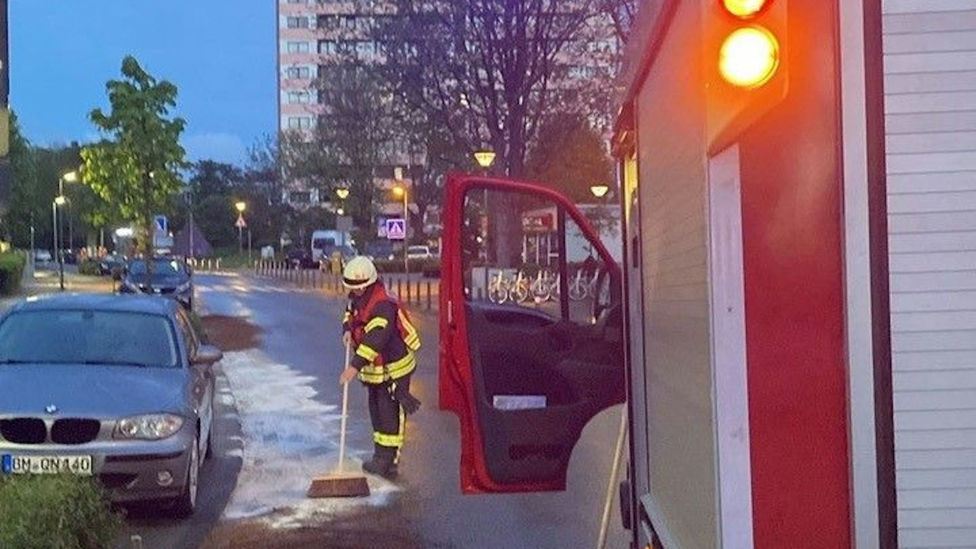 Auf dem Foto ist ein Feuerwehrmann zu sehen, der eine Ölspur bindet.