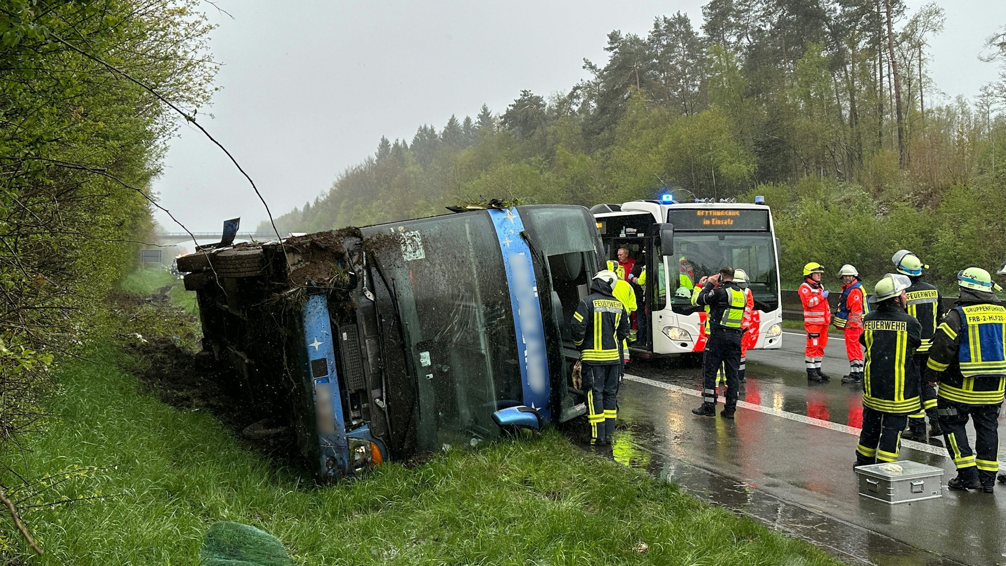 Ein Bus liegt umgefallen am Straßenrand.