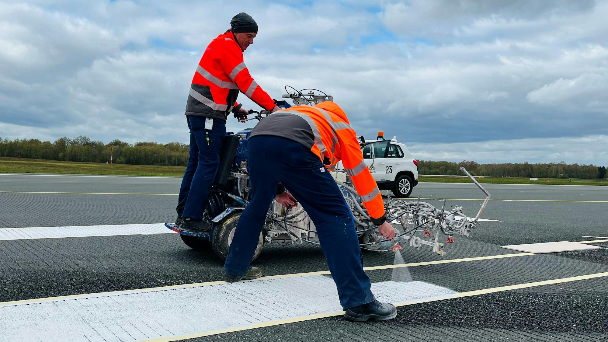 Arbeiter versehen eine Start- und Landebahn auf dem Flughafen Köln/Bonn mit neuen Markierungen.