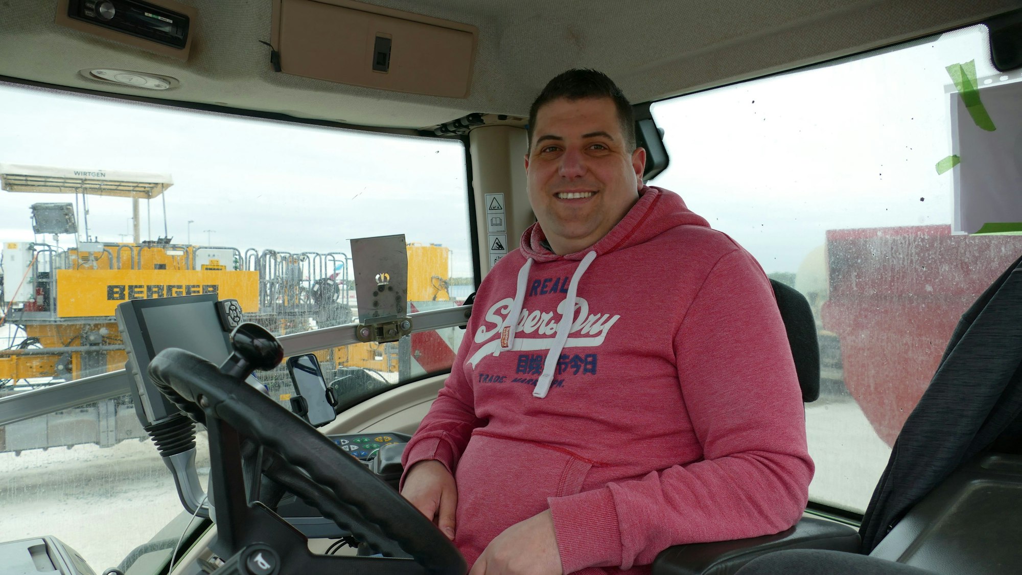 Ein Mann sitzt in einem Baufahrzeug.