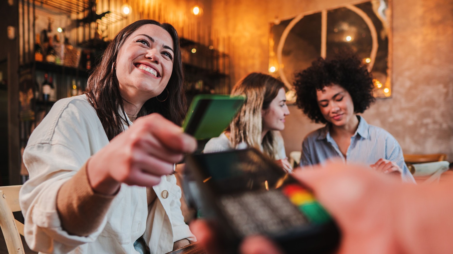 Junge Frau bezahlt mit Karte