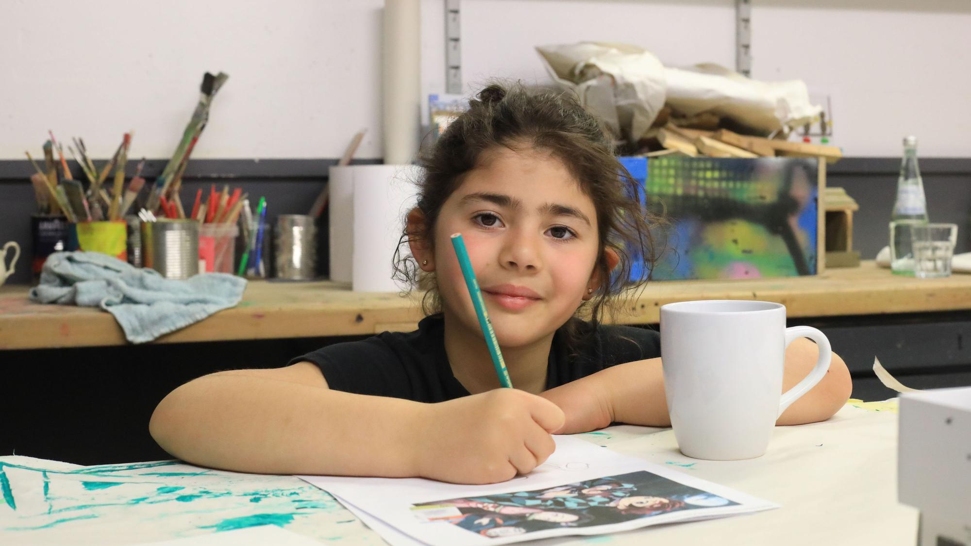 Die neunjährige Ela hat Spaß bei der Arbeit. Ein Motiv ihrer Lieblingsmangaserie will sie auf die Tasse malen.