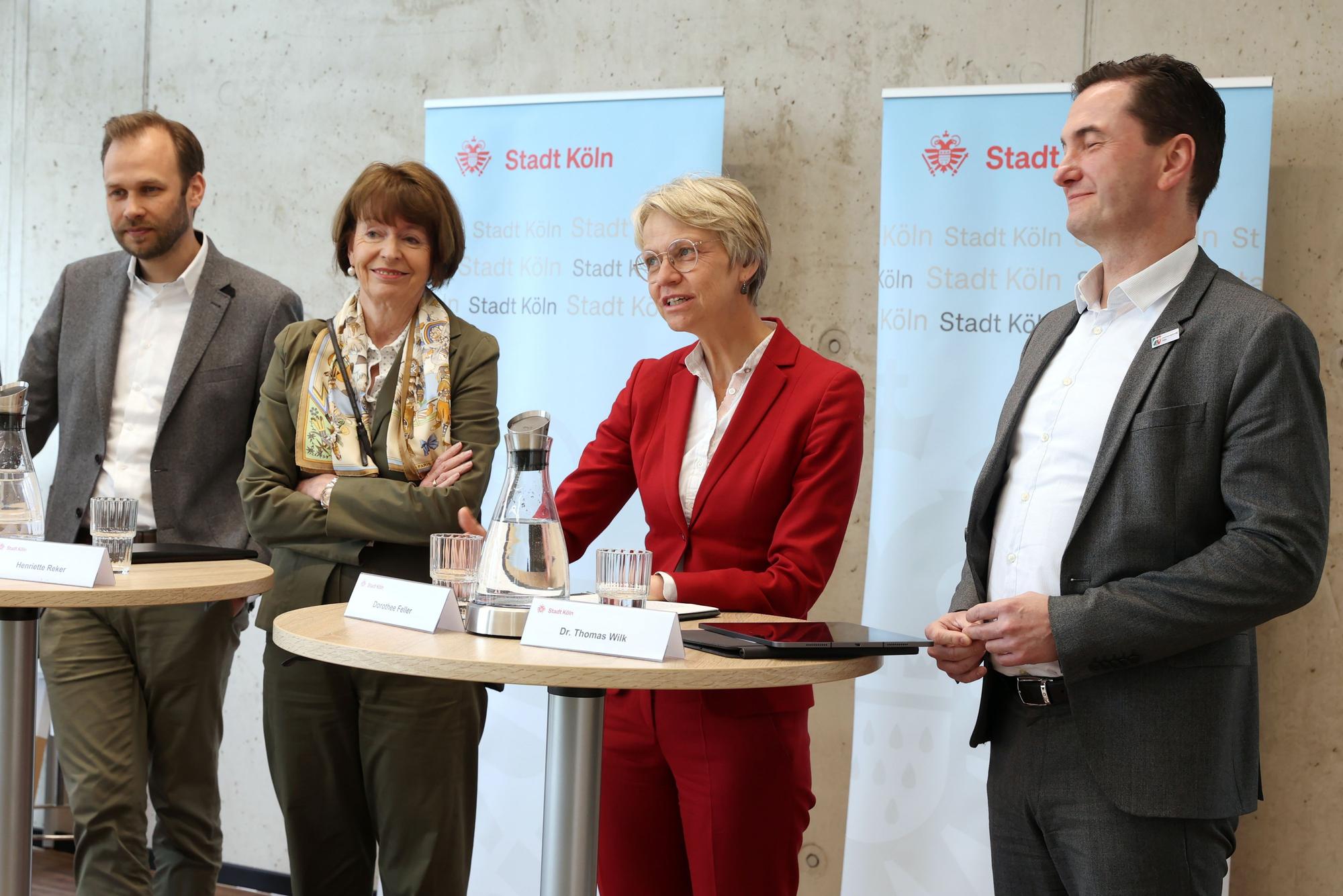 Vier Menschen stehen nebeneinander.