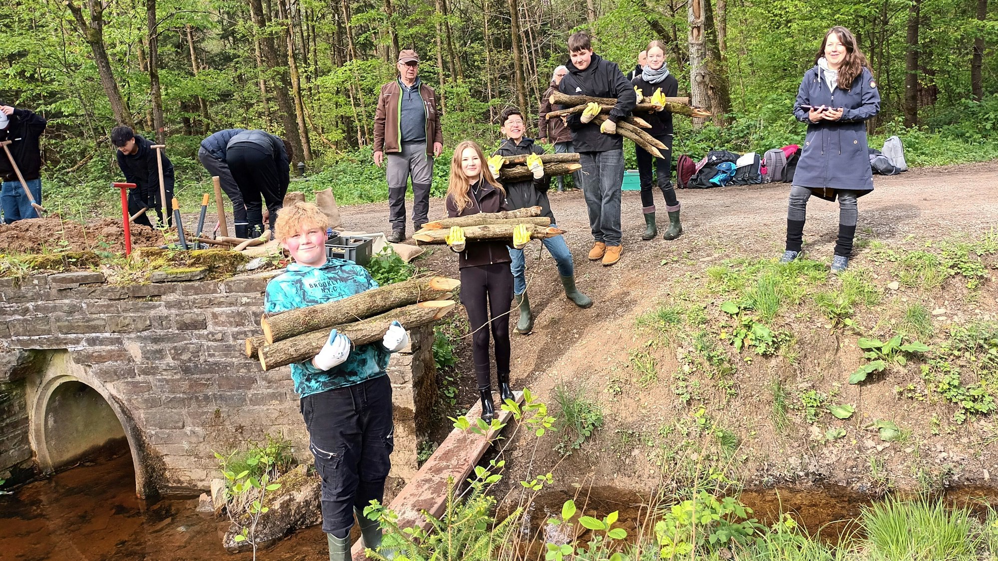 Jugendliche tragen angespitzte Holzstämme