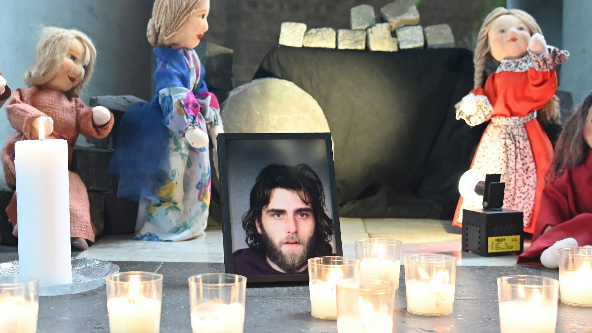 Foto eines Obdachlosen, der vor wenigen Wochen auf der Straße starb, eingerahmt von Teelichtern und Stoffpuppen