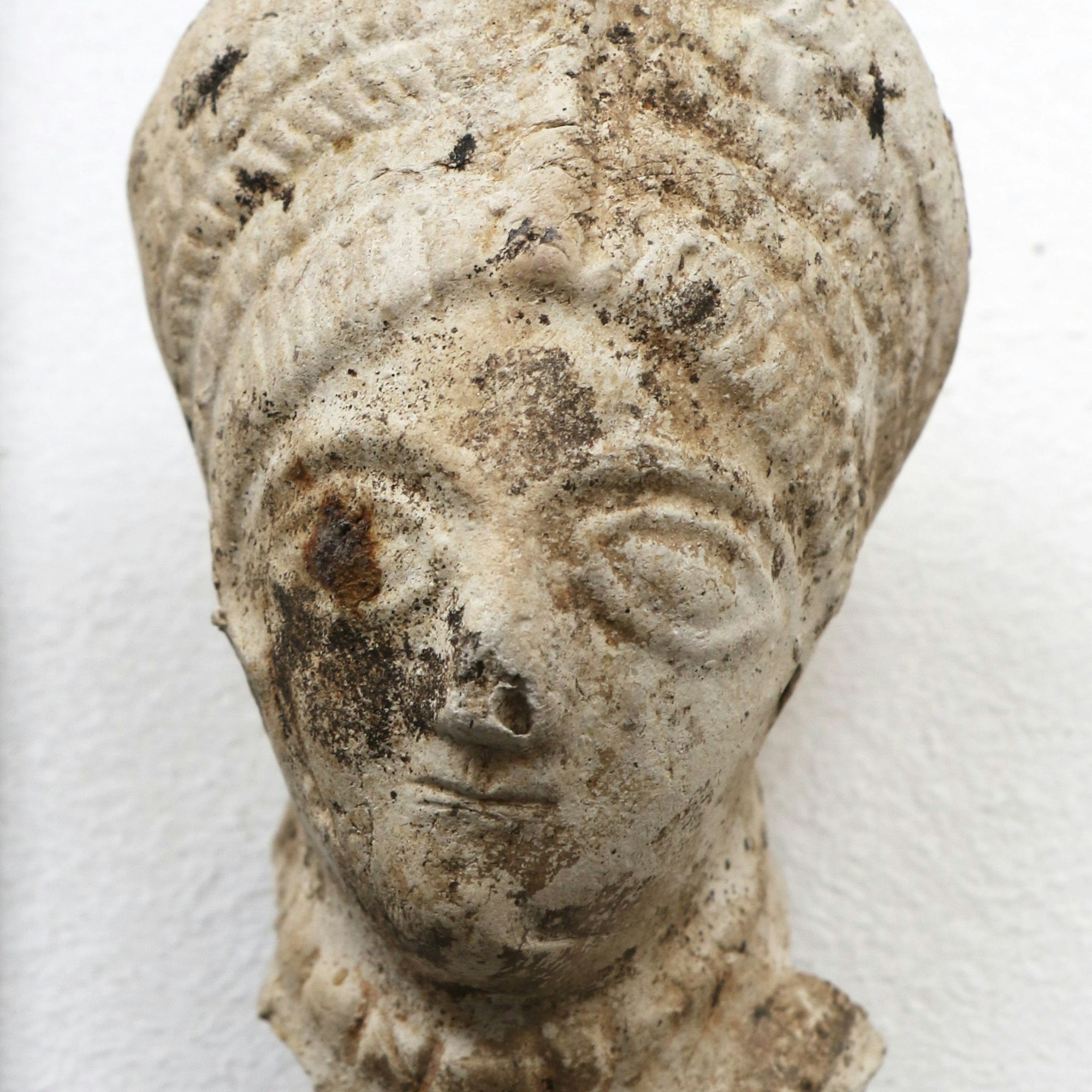 Eine antike römische Terrakottafigur in heller Farbe.