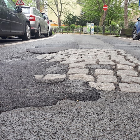 Der Asphalt in Höhe des Bremskissens auf der Hartwichstraße ist deutlich geschädigt.