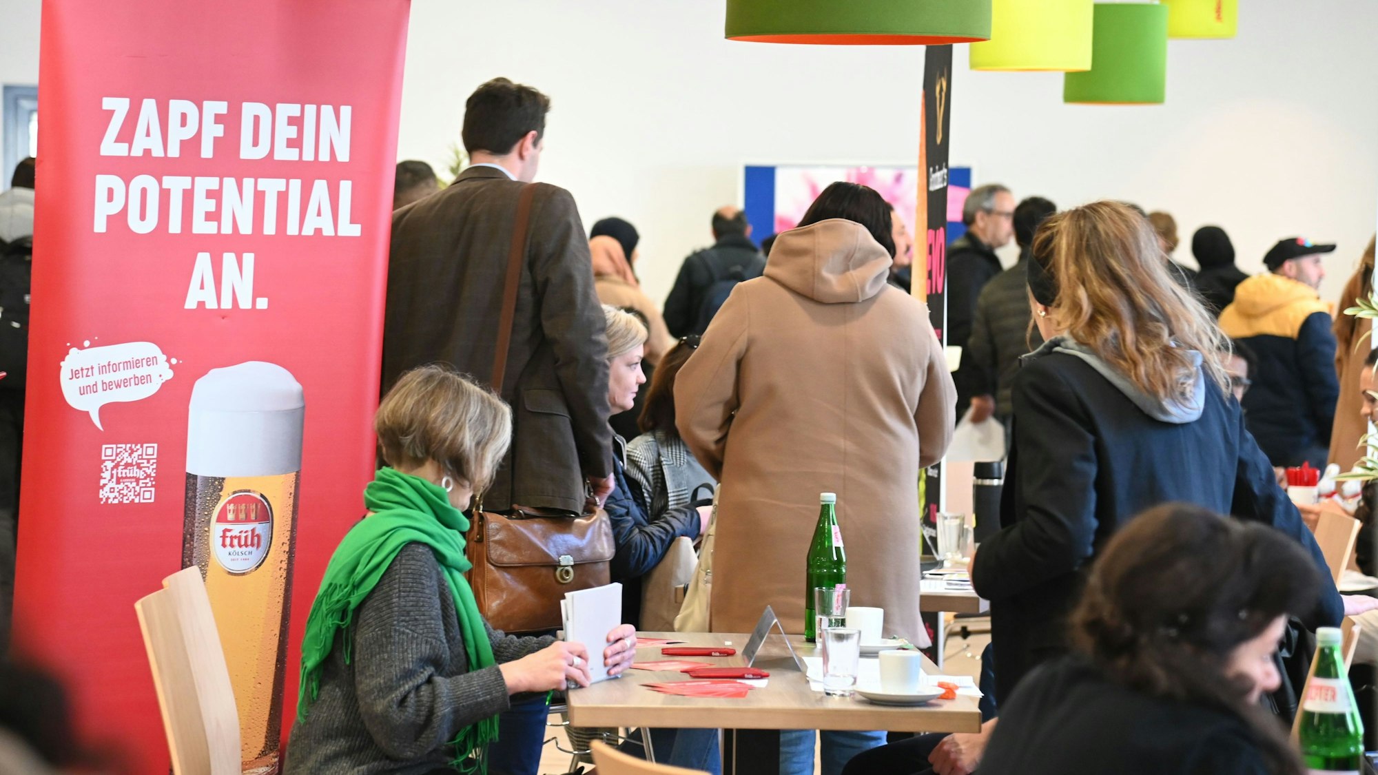 Menschen laufen zwischen Infoständen entlang.