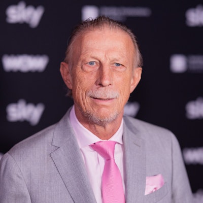 Christoph Daum steht auf dem Roten Teppich.